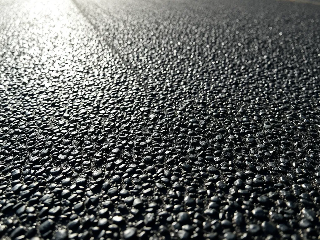 Close-up view of asphalt surface showing texture and moisture effects related to local weather patterns