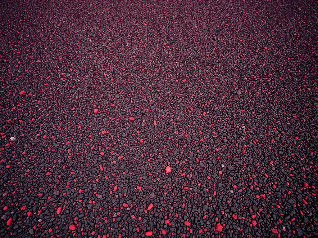 Textured asphalt driveway with red and black stones for customization options